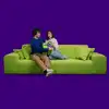 Pax - Zwei Personen sitzen auf einem grünen Sofa und halten gemeinsam ein Pax Care Geschenk mit Pax-Band.